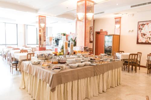 a long table with food on it in a restaurant at Hotel Nettunia in Rimini