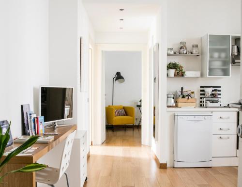 a white kitchen with a desk and a yellow chair at Lovely Sempione Apartment in Milan