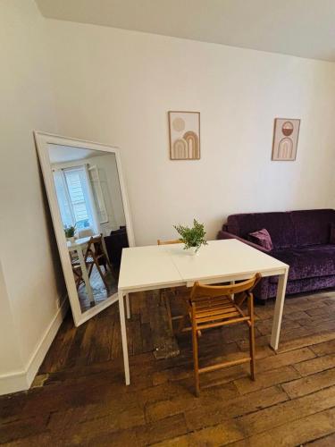 - un salon avec une table et un miroir dans l'établissement Appartement Boucicaut Tour Eiffel, à Paris