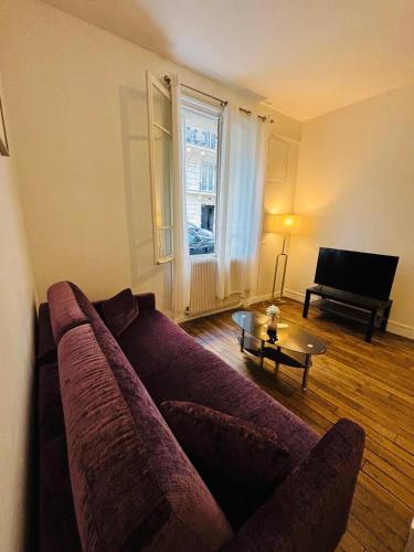 un salon avec un canapé et une table dans l'établissement Appartement Boucicaut Tour Eiffel, à Paris