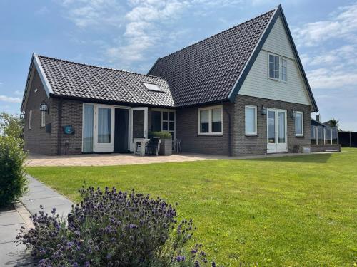 a house with a green lawn in front of it at Landhuis Mariëtta in De Koog
