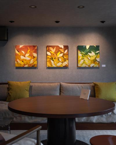 a table in a room with four paintings on the wall at TheMana Village in Tosashimizu