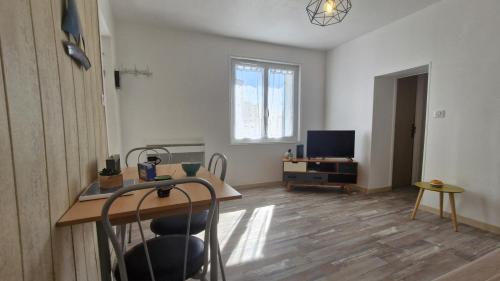 un salon avec une table et une télévision dans l'établissement Saint Palais sur Mer - PROXIMITÉ LAC pour cette petite MAISON MITOYENNE - WIFI, à La Palud