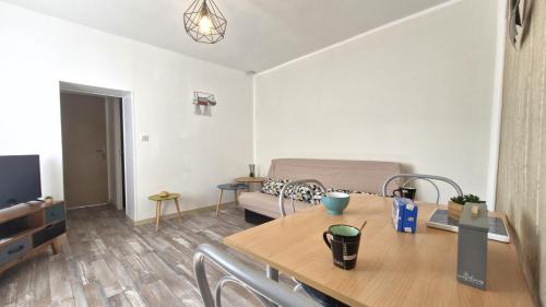 un salon avec une table et un canapé dans l'établissement Saint Palais sur Mer - PROXIMITÉ LAC pour cette petite MAISON MITOYENNE - WIFI, à La Palud