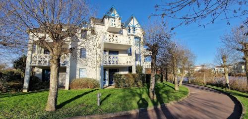 un grand bâtiment blanc sur une cour herbeuse avec des arbres dans l'établissement 