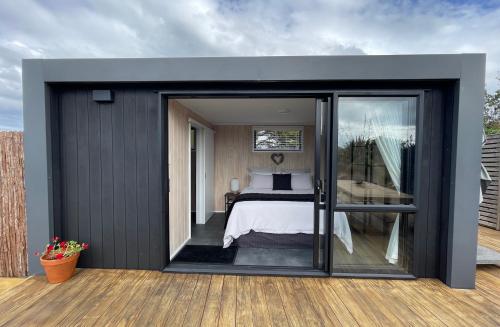 a bedroom with a bed and a sliding glass door at Ocean Vista Tutukaka in Tutukaka