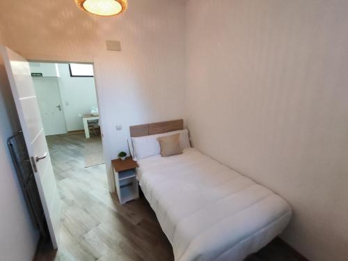 a bedroom with a white bed in a room at Apartamentos VALDECILLA nuevos in Santander
