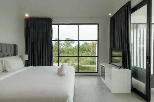 a bedroom with a white bed and a large window at Villa Valeria in Ungasan