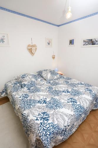 une chambre avec un lit avec une couverture bleue et blanche dans l'établissement St Cyprien Appartement a 2 pas du port et de la plage, à Saint-Cyprien