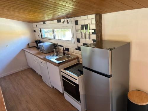 a small kitchen with a refrigerator and a sink at Escale in Domalain