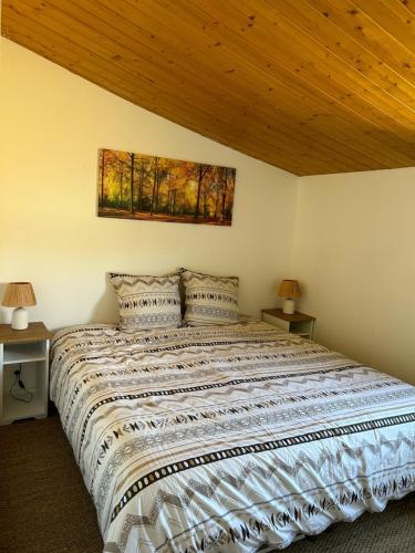 a bedroom with a large bed with a wooden ceiling at Escale in Domalain