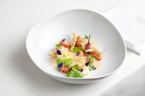 a white bowl filled with food on a table at TAUROA Landhaus zu Appesbach in St. Wolfgang