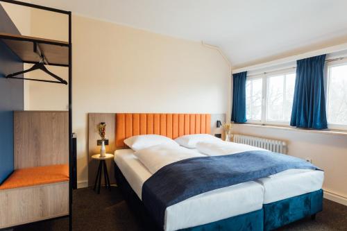 une chambre avec un grand lit et un miroir dans l'établissement MYKY Hotel Pinneberg - Free Parking, à Pinneberg