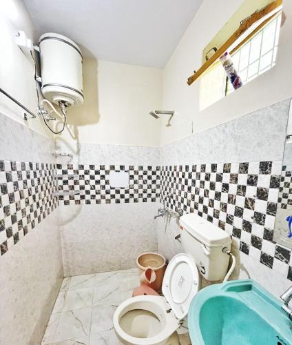 a bathroom with a toilet and a sink at The Founder's Tribe in Bīr