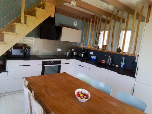 - une cuisine avec une table en bois et un bol de fruits dans l'établissement Jolie petite maison à 7 min à pied de la plage pour 6 pers, à Saint-Nic