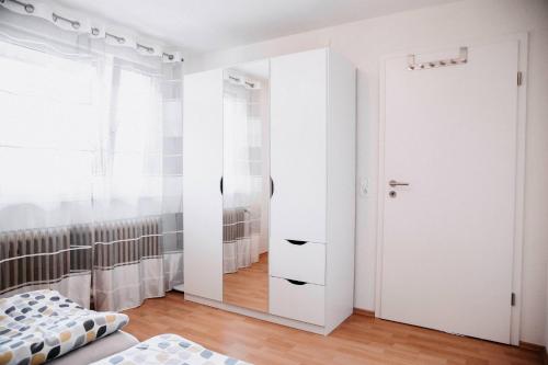 a bedroom with white walls and a white closet at Auszeit am See in Moos