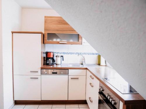 a kitchen with white cabinets and a sink at Auszeit am See in Moos
