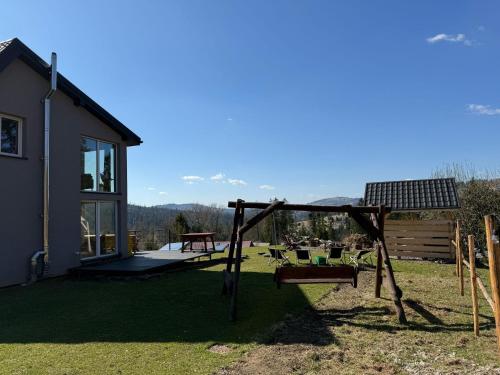 a backyard with a swing set and a house at LUCE Chata in Nieledwia