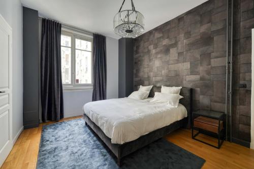 une chambre avec un lit et un mur de briques dans l'établissement Appartement Bugeaud Luxury, à Paris