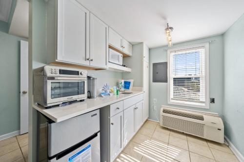 a kitchen with white cabinets and a microwave at Beachview 312 in Gulf Shores