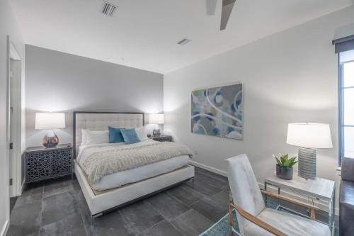 a white bedroom with a bed and a chair at 121 Hotel Floor 3 Buyout by AvantStay Entire Third Floor Buyout of 121 Hotel Sleeps 18 in Nashville