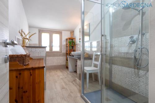 Un baño con ducha de cristal y lavabo. en ClickSardegna Villa dei Limoni with pool close to the beach, en Fertilia