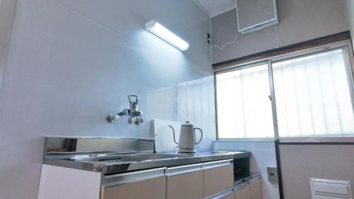 a small kitchen with a sink and a window at MSTAY東池袋one in Tokyo