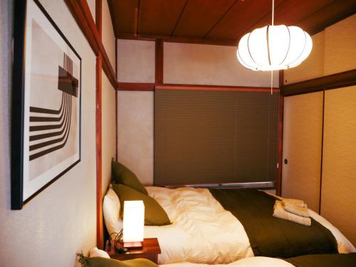a bedroom with a bed and a chandelier at MSTAY東池袋one in Tokyo