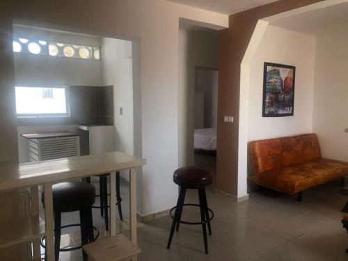 kuchnia i salon ze stołem i stołkiem w obiekcie studio sacre coeur w mieście Dakar