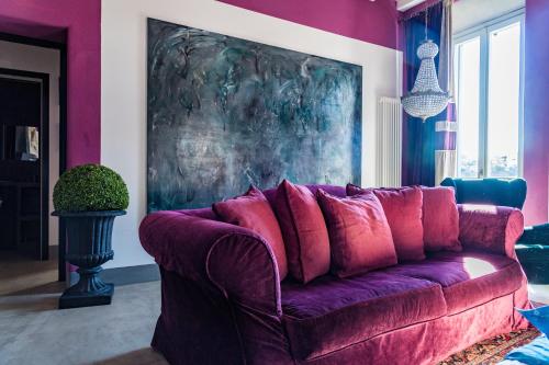 a purple couch in a living room with a painting at Luxury House FV in Formello