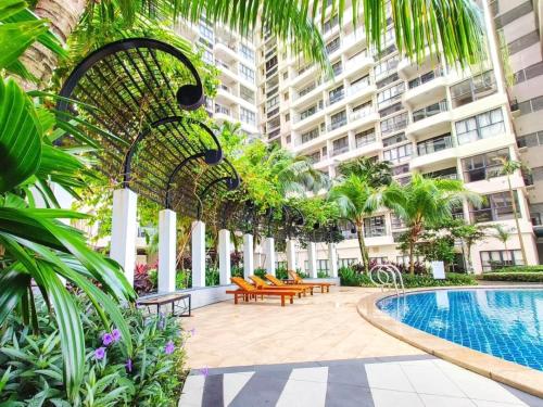 a courtyard with benches and a swimming pool in a building at Royal Strand Country Garden Danga Bay in Johor Bahru