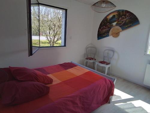 - une chambre avec un lit coloré et une fenêtre dans l'établissement Jolie petite maison à 7 min à pied de la plage pour 6 pers, à Saint-Nic