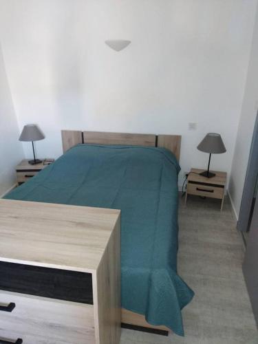 une chambre avec un lit avec une couverture verte dans l'établissement Le porche, à Moissac-Bellevue