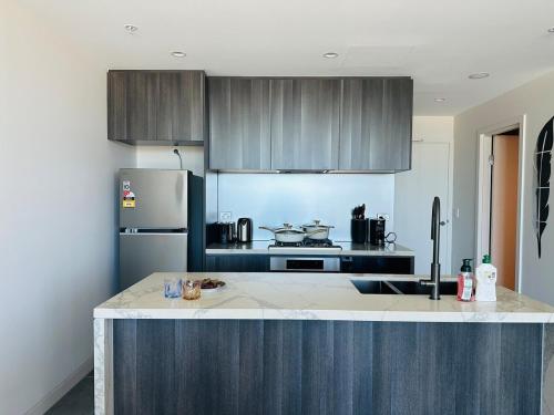 a kitchen with a refrigerator and a counter top at Golden Sunset Retreat In Olympic Park in Sydney