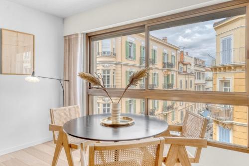 une salle à manger avec une table et une grande fenêtre dans l'établissement Gray d'Albion Studio, Hypercenter 2 min from Palace of festival, à Cannes