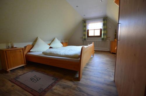 a bedroom with a bed with white sheets and a window at Haus Anna in Sendelbach
