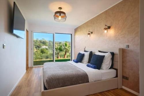 une chambre avec un grand lit et une grande fenêtre dans l'établissement Villa de Luxe Vue Mer Les Oiseaux du Paradis, à Cavalaire-sur-Mer