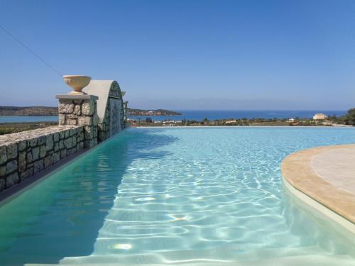 a swimming pool with the ocean in the background at Porto Panorama in Porto Heli