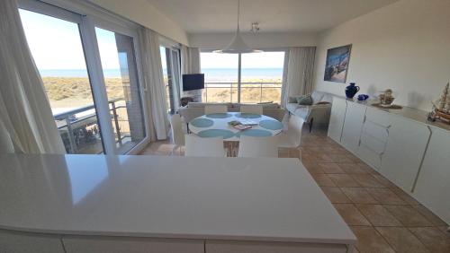 a kitchen and living room with a view of the ocean at Zeemeermin in Nieuwpoort
