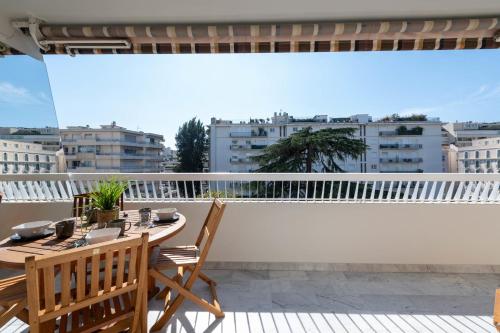 d'un balcon sur le toit avec une table et des chaises. dans l'établissement Spacious 1-Br Apartment with Terrace Heart of Cannes, à Cannes