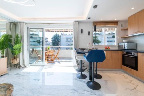 une cuisine avec un comptoir et un fauteuil bleu dans l'établissement Spacious 1-Br Apartment with Terrace Heart of Cannes, à Cannes