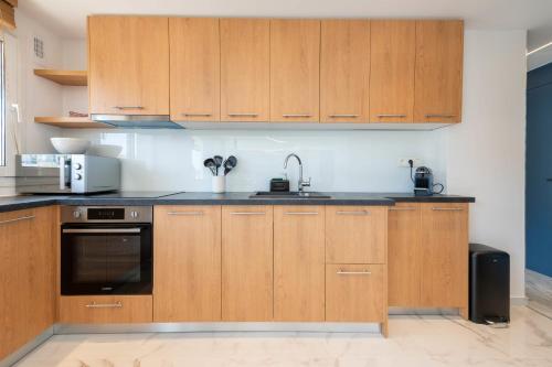 une cuisine avec des armoires en bois et un évier dans l'établissement Spacious 1-Br Apartment with Terrace Heart of Cannes, à Cannes