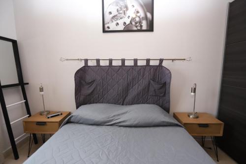 ein Schlafzimmer mit einem Bett mit zwei Nachttischen und zwei Lampen in der Unterkunft Saint Cyprien jolie villa avec piscine in Saint-Cyprien