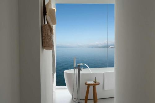 a bathroom with a tub and a view of the ocean at Shenzhen GuanHu Secret Wild Reef Seaview Hotel in Shenzhen