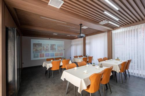 a dining room with white tables and orange chairs at Peking Courtyard Qianmen in Beijing