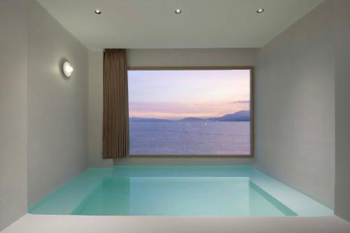a room with a window overlooking the water at Shenzhen GuanHu Secret Wild Reef Seaview Hotel in Shenzhen