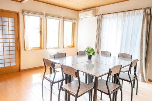a dining room with a table and chairs at House Villa Kagura in Asahikawa