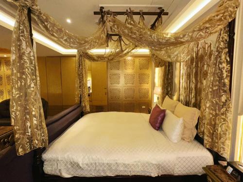 a bedroom with a canopy bed with curtains at Merry Day Motel Zhonghe Branch in Zhonghe