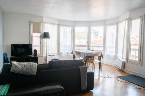 un salon avec un canapé et une table dans l'établissement Spacious T4 near town center, à Boulogne-Billancourt