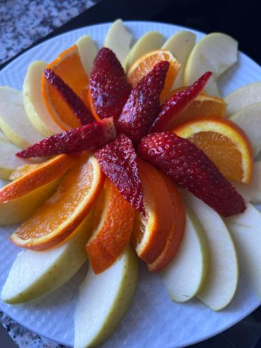 a white plate with oranges and apples on it at Aloha House in Shkodër